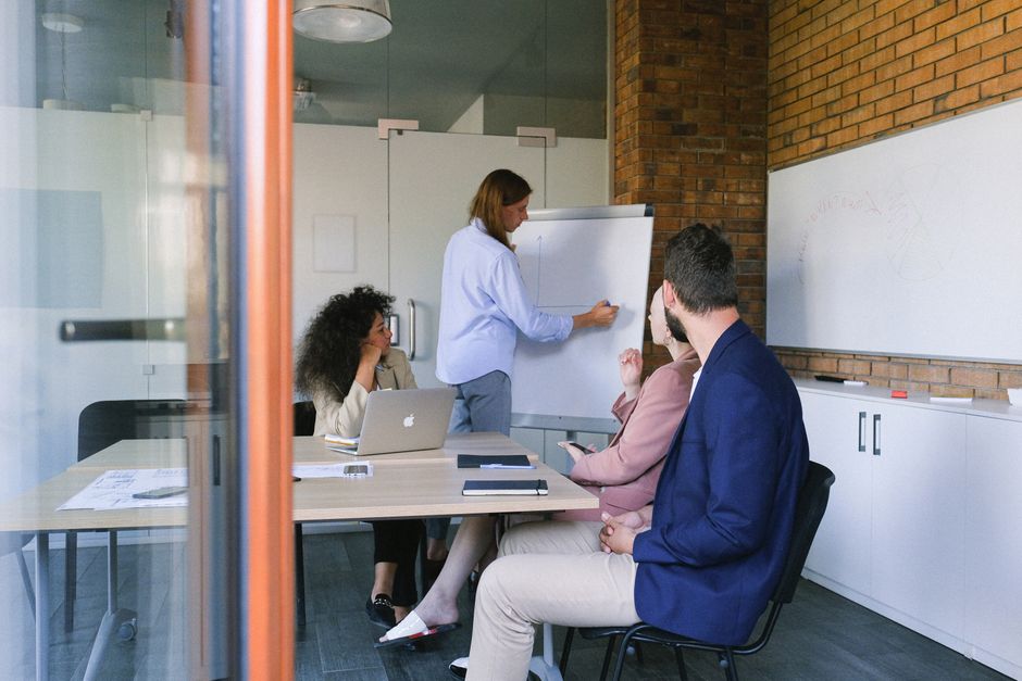 Concentrated colleagues sitting at table in modern workplace and discussing details of project during meeting in daytime
